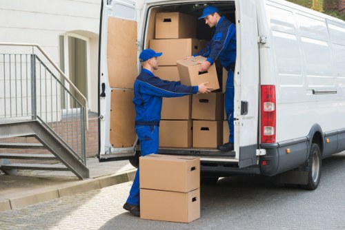 Front view of a moving van with crew loading items, representing London man and van services